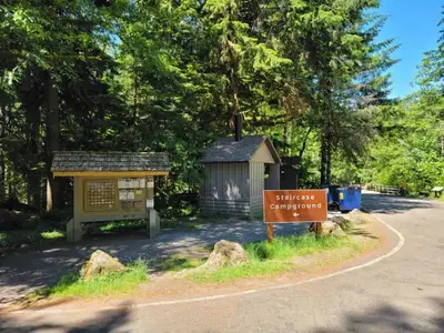 The entrance to Staircase Campground with a campground registration board and a pit toilet.