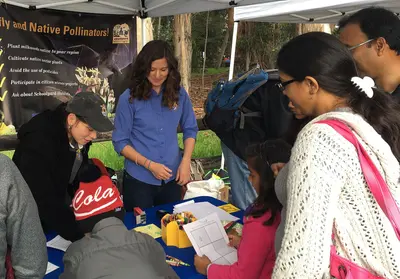 Biologists Karen Sinclair and Lara Drizd assisting children color their paper cut-outs of monarch butterflies. (32594937622)