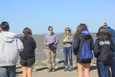 Student presentations on Sherman Island, overlooking Shiloh Wind Power Plant and the Sacramento River.