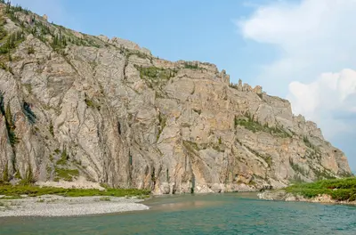 Rock face overlooking Firth River at Muskeg Creek confluence, Ivavvik National Park, YT