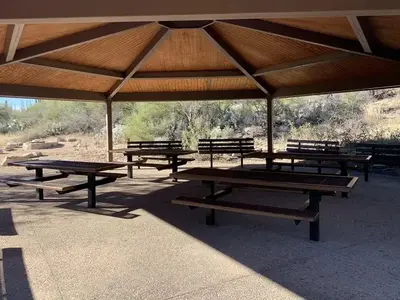 Under the ramada, with a view of picnic tables and benches