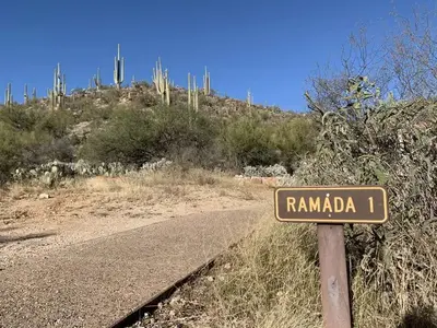 Paved path to the left of a sign saying "Ramada 1"