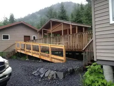 Deep Bay Cabin exterior with accessible ramp to the porch and gravel driveway in foreground