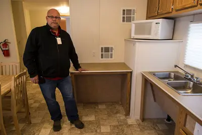 David Glidewell, FEMA Contracting Officer Representative, stands next to a wheelchair accessible kitchen counter in a Uniform Federal Accessibility Standard (UFAS) Manufactured Hous - DPLA - e49839fae3a5225c59131a4bc76148f6