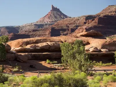 A picnic table adjacent to Hamburger Rock geologic feature with a Six Shooter peak in the background.
