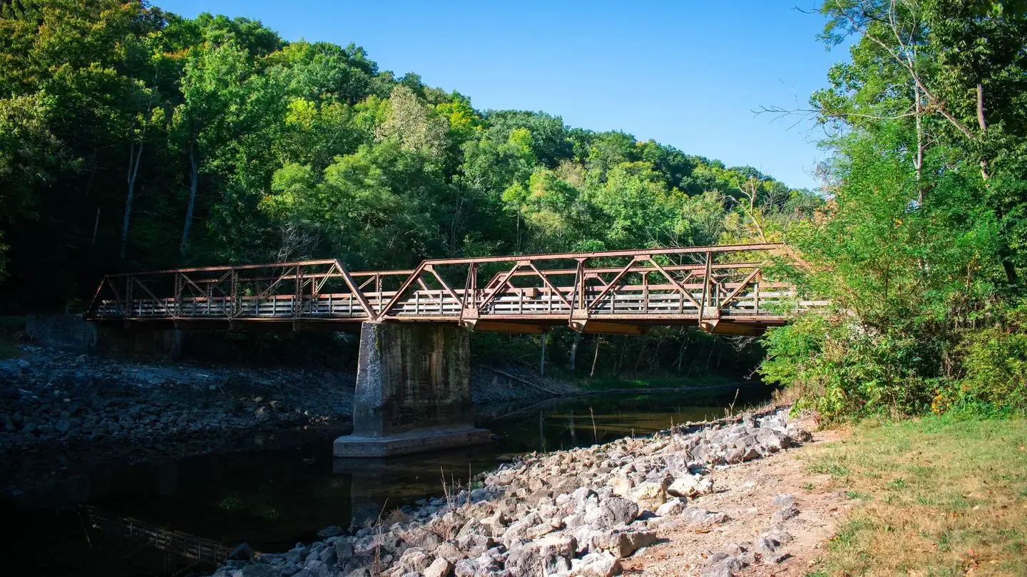 Steel bridge over green tailwater outflow