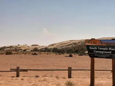 Wide angle photo of campground with sign in foreground that says "South Temple Wash"