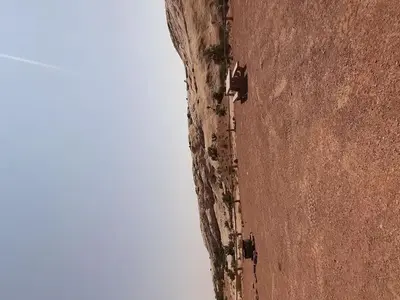 A primitive campsite on gravel ground with a fire ring and picnic table.