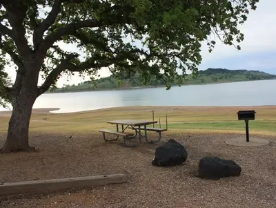 Day use area picnic site with table and barbecue pedestal.