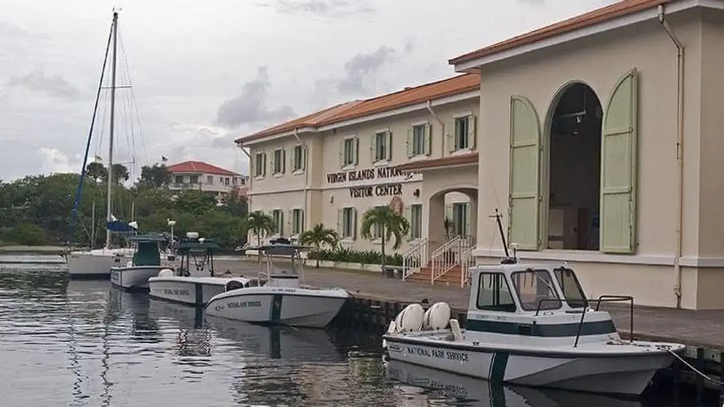 Virgin Islands National Park Visitor Center with National Park Service boats parked in the water in front of the building.