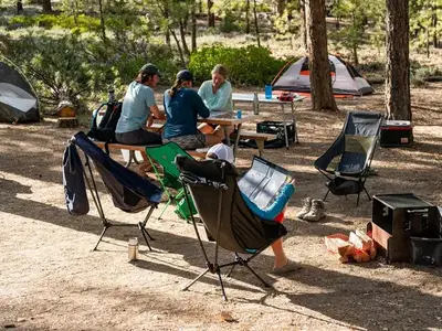 Tent campers relax at a picnic table at Sunset Campground