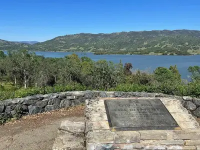 Coyote Dam & Lake Mendocino plaque mounted to stone wall, with view of Lake Mendocino in the background