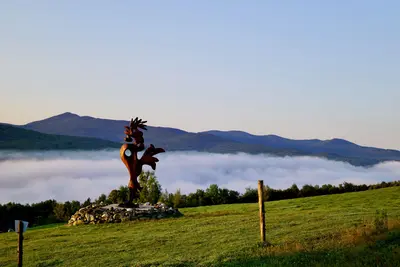Rooster sculpture above fog Sutton Quebec
