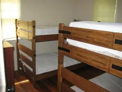 Cabin bunk room with two bunk beds and a dresser.