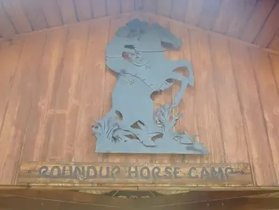 A metal sculpture depicting  a cowboy on a bucking bronco at Roundup Horse Camp