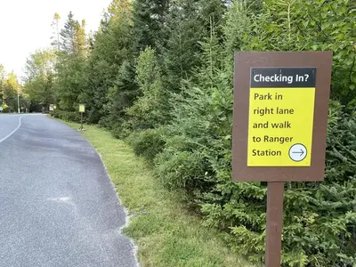 Camper check in sign stating- park in right lane and walk to ranger station