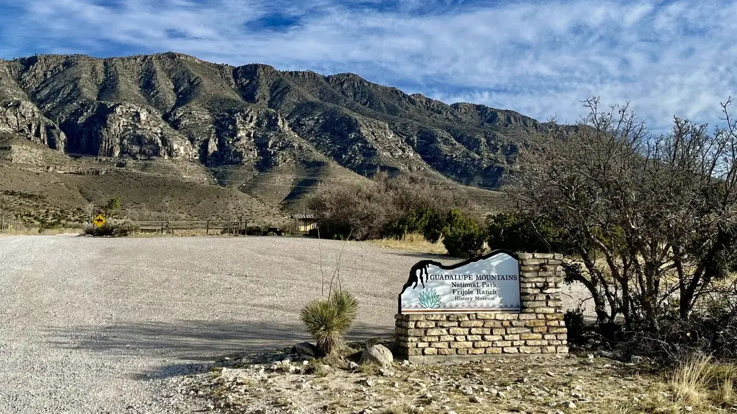 Entry sign to the Frijole Ranch area with view of the mountains in the background and the Frijole Horse Corral campground.