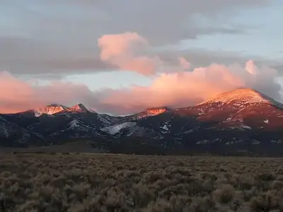 Snowy mountain peaks glowing with sunrise colors