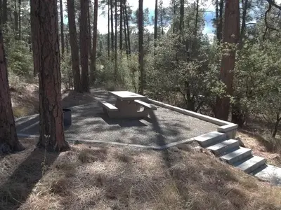 White Spar Campsite with table and fire ring on raised rock walled platform