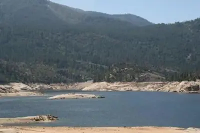 A shallow mountain lake on a blue sky day