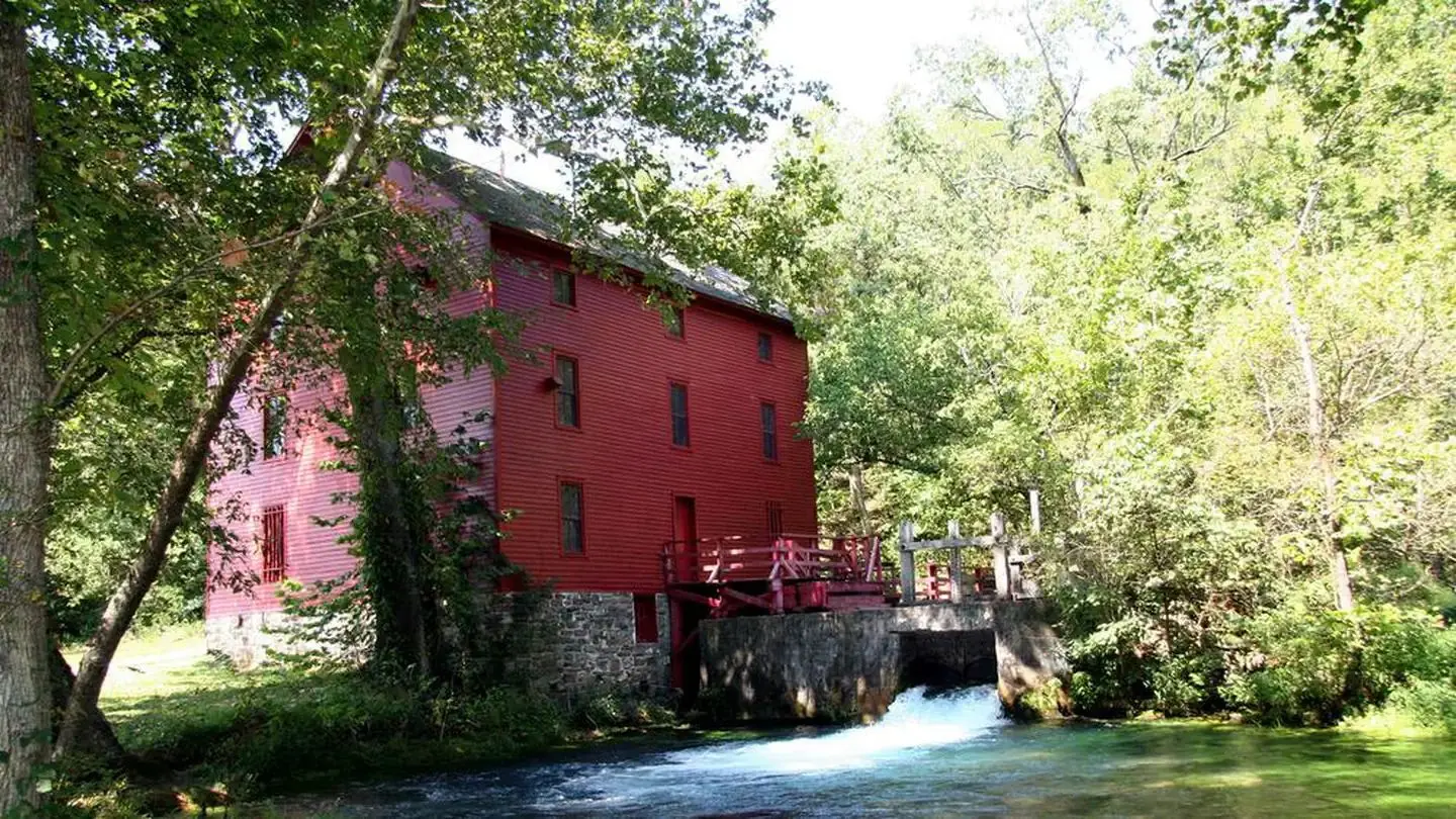 Bright red Alley Mill under the summer sun and shade trees