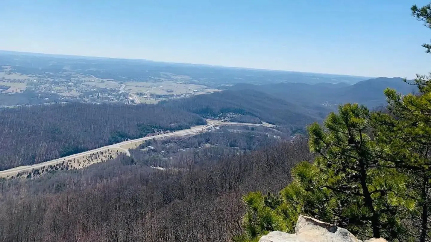 A blue sky with trees and mountains.
