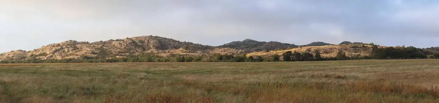 Granite mountains rise above the grasslands.