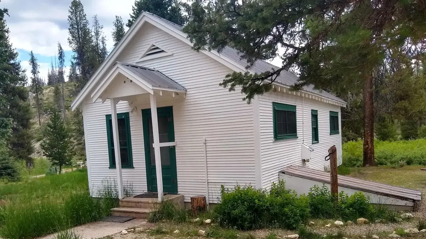 A white cabin in the woods.