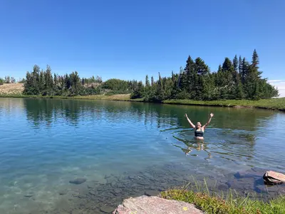Woman swims in alpine lake in Goat Rocks Wilderness