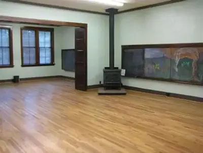 GROOM CREEK SCHOOLHOUSE interior fire place, wooden floors and mural on the right wall