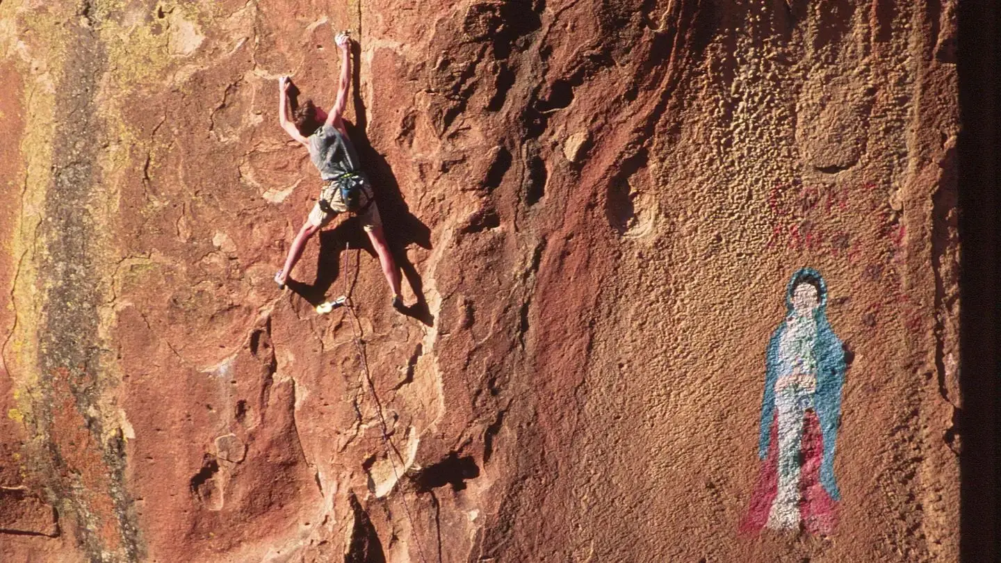 Climber in Penitente Canyon adjacent to pictograph of the Virgen de Guadalupe