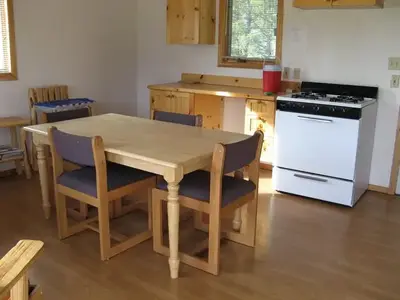 A small wooden kitchen table and counters in a cabin