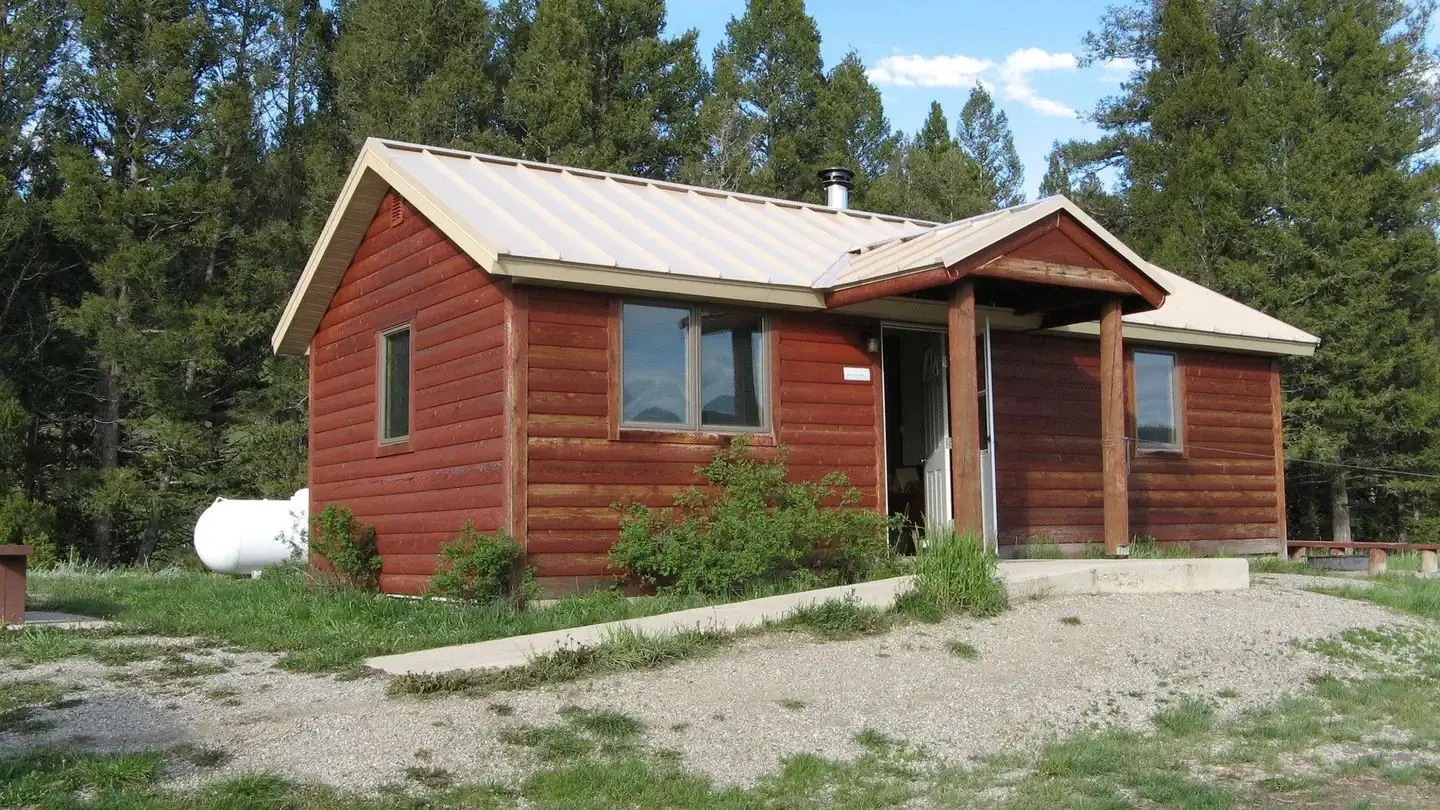 A red wooden cabin with two wings