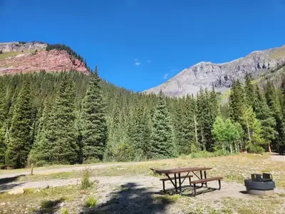 Campsite with fire ring and picnic table and mountains views