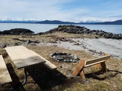 Picnic table and fire ring on sand beach