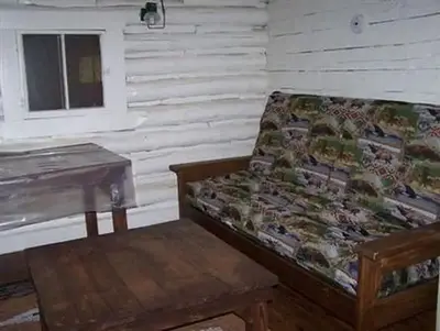 A corner of the Hull Cabin living room with two tables and a futon in the upright position.