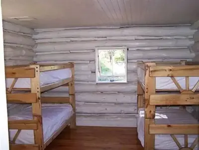 A pair of wood-frame bunk beds in a cabin bedroom.