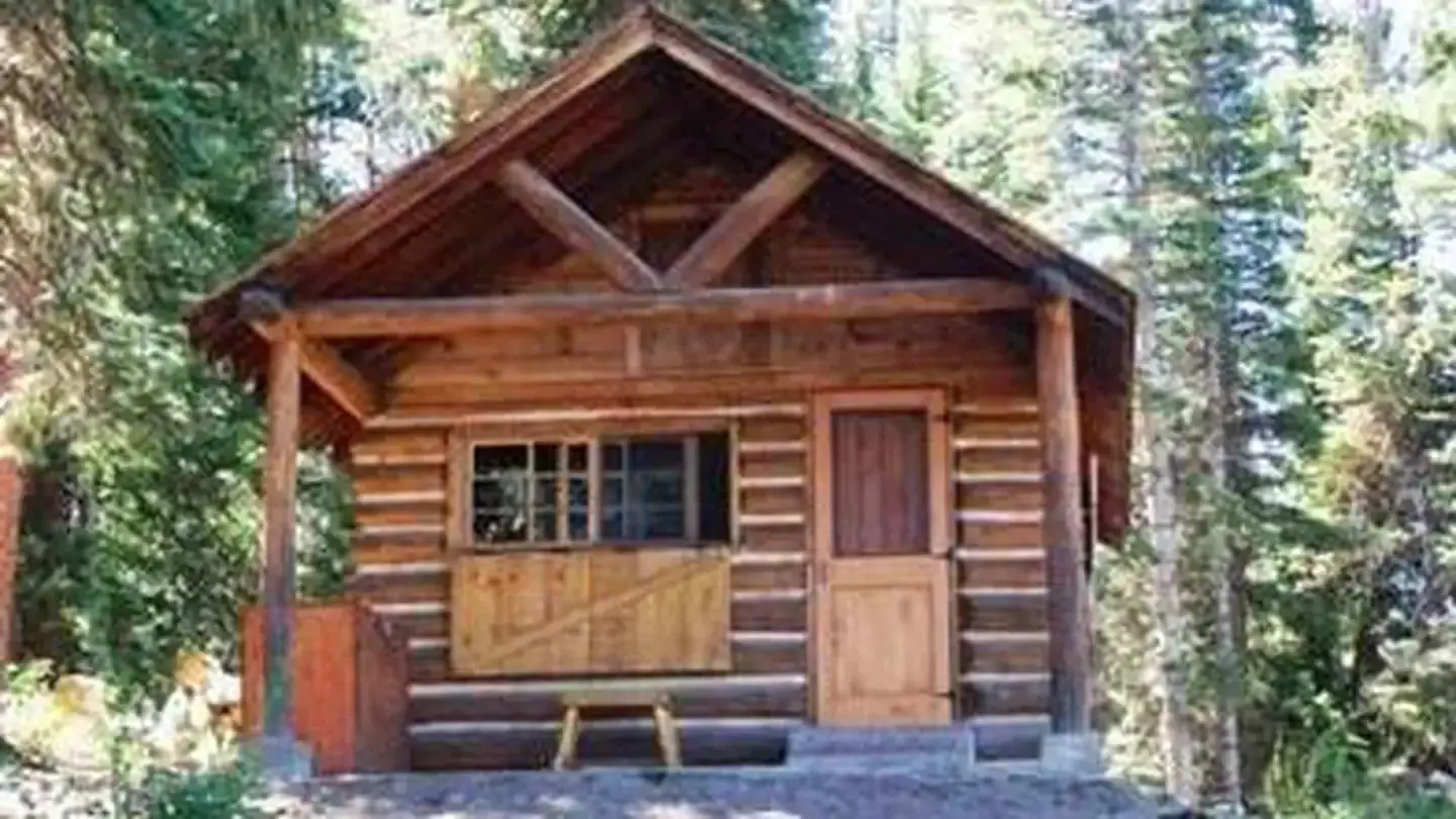 The front of a wooden cabin in a forest