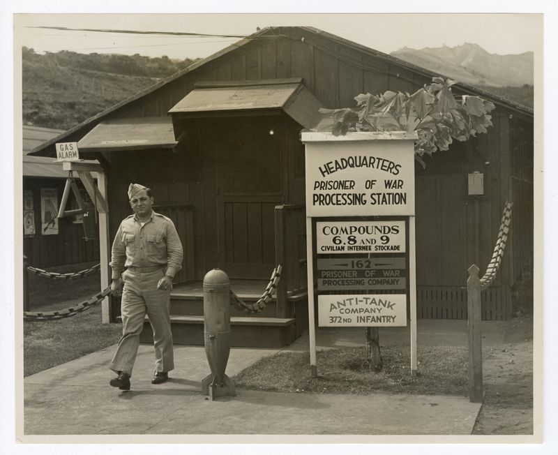 A historic photo of a soldier walking out of a barrack
