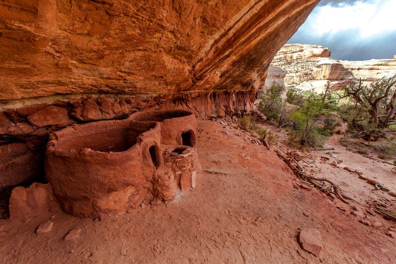Two small structures beneath a sandstone alcove