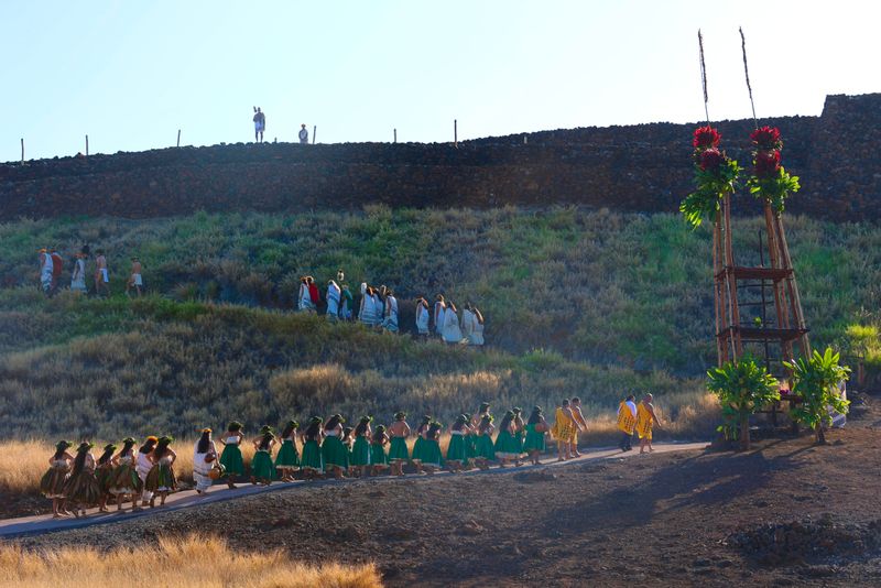 Ceremony procession along a heiau at sunrise.