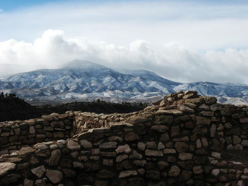 4 foot masonry walls with mountains and clouds behind them.