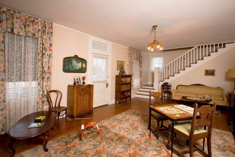 A view of the formal living room features a tricycle, table and chairs, and radio